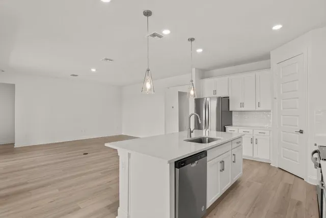 a kitchen with kitchen island a sink stainless steel appliances and cabinets