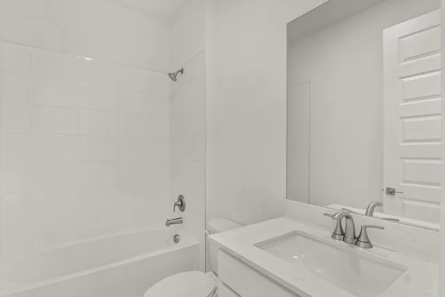 a bathroom with a granite countertop sink a toilet and shower