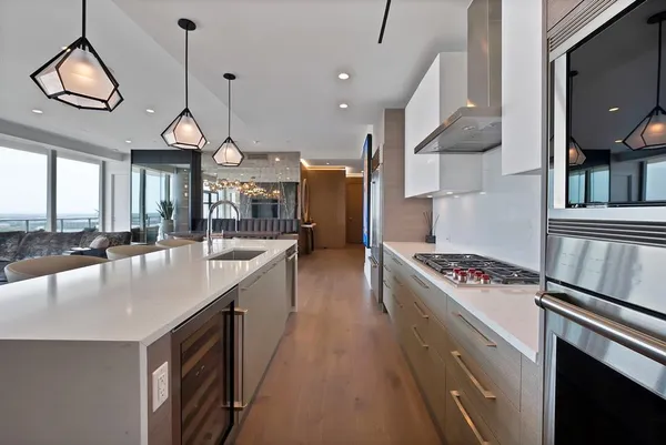 a kitchen with stainless steel appliances granite countertop a sink a stove and a wooden floors