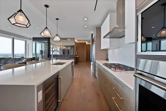 a kitchen with stainless steel appliances granite countertop a sink a stove and a wooden floors