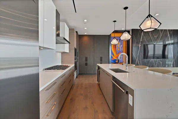 a large kitchen with stainless steel appliances granite countertop a sink and a refrigerator