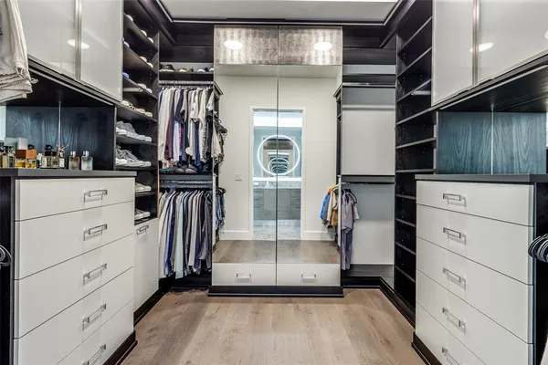 a view of walk in closet with clothes and shoes