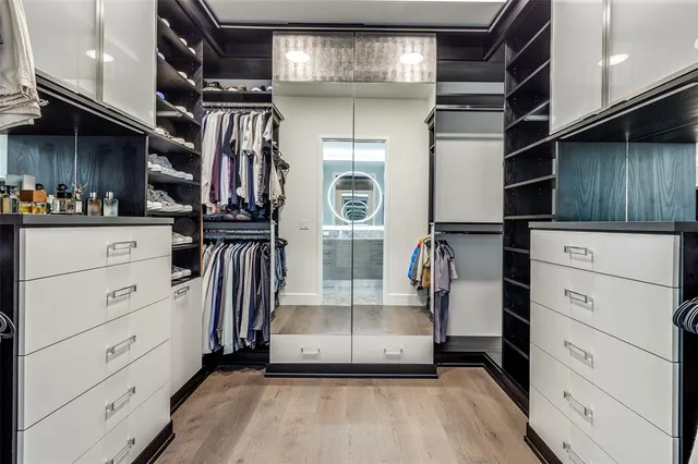 a view of walk in closet with clothes and shoes