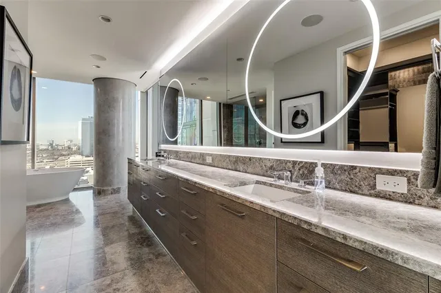 a bathroom with a granite countertop double vanity sink and a mirror