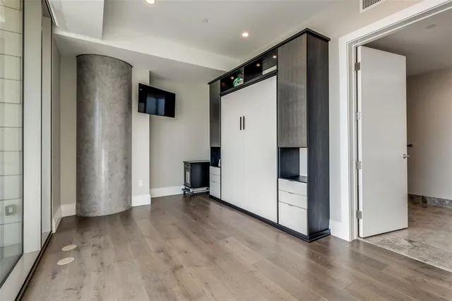 an empty room with wooden floor and white doors