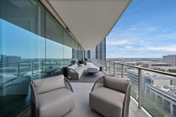 a balcony with furniture and a view of city