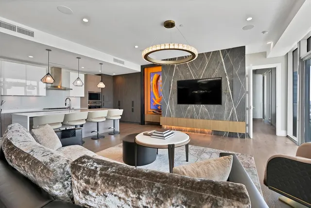a living room with furniture a flat screen tv and kitchen view