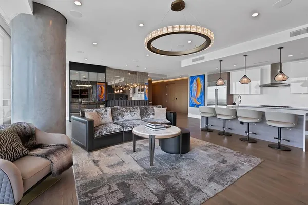a living room with furniture kitchen view and a window