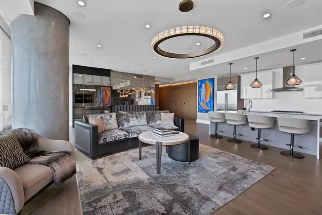 a living room with furniture kitchen view and a window