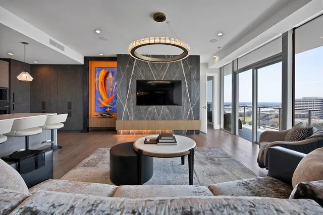 a living room with furniture a rug and a floor to ceiling window