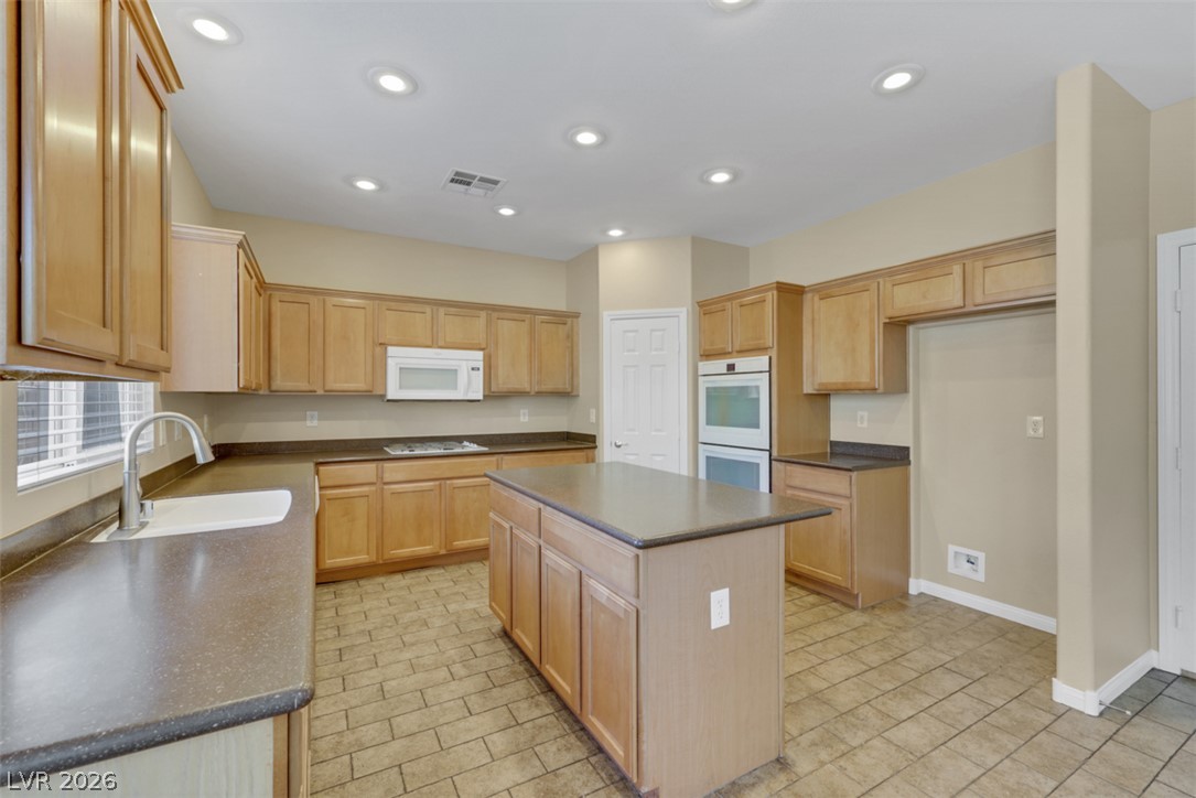 10328 Hawk Ravine Street Las Vegas, NV 89178 - Photo 14 of 55 Well-lit kitchen with a spacious island, built-in appliances, and ample cabinetry for storage.