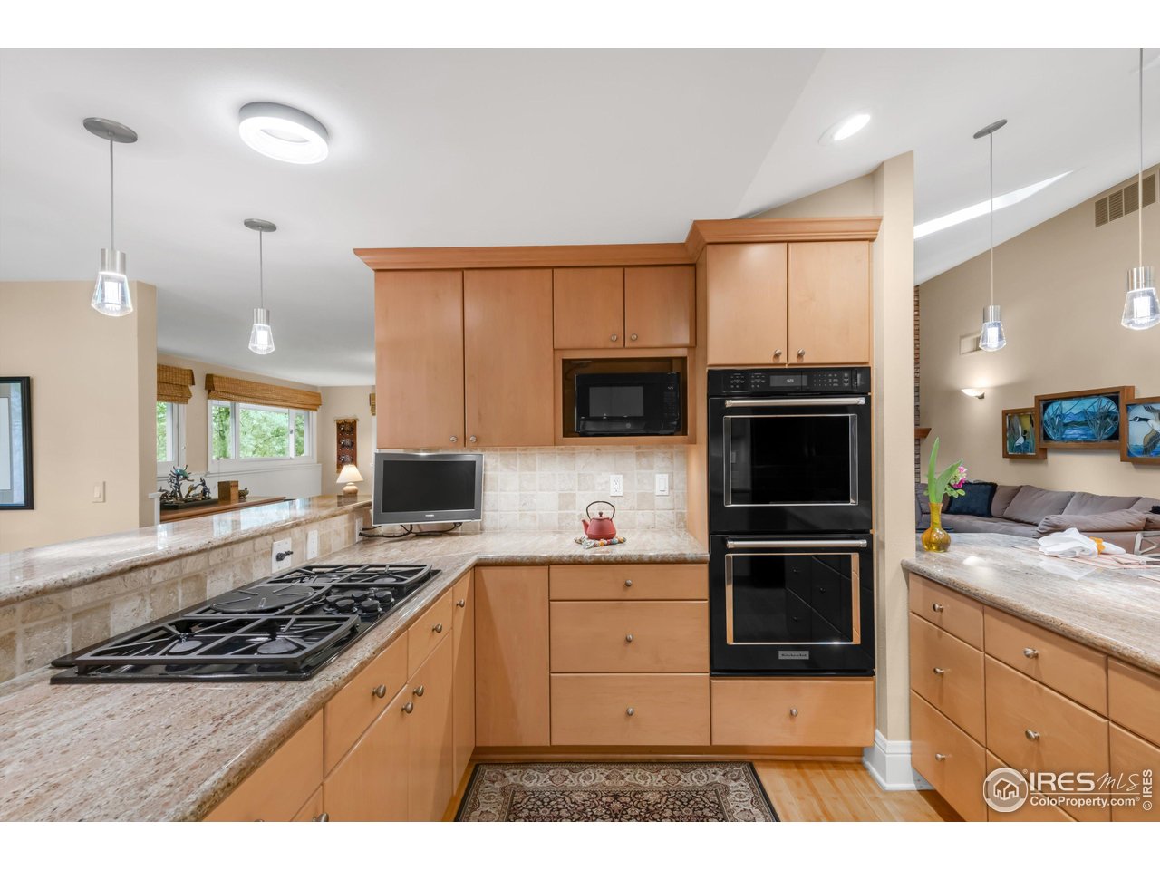 1409 Old Tale Road Boulder, CO 80303 - Photo 11 of 40 a kitchen with stainless steel appliances kitchen island granite countertop a stove a sink and a microwave