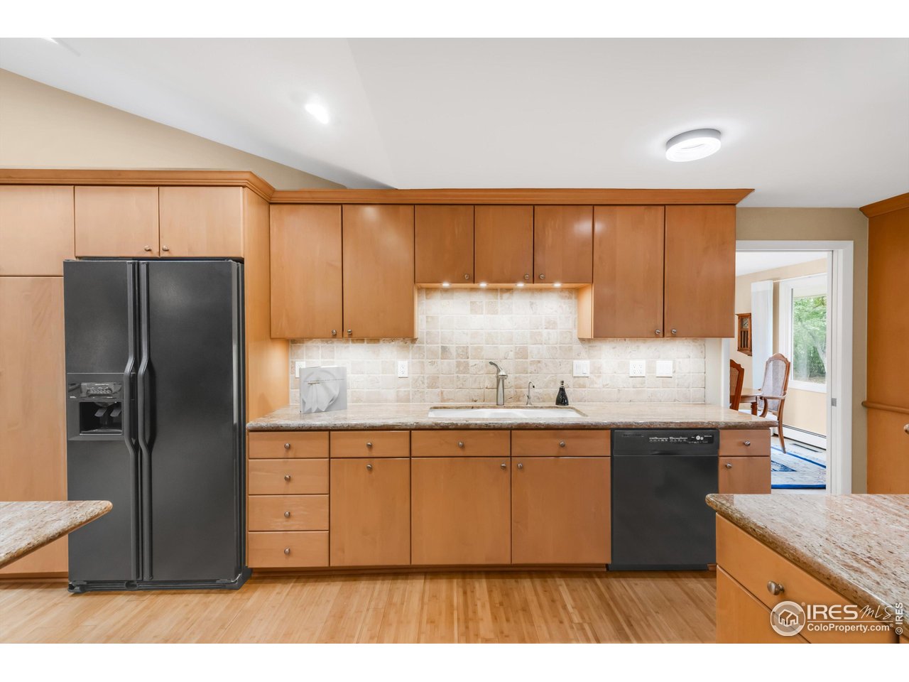 1409 Old Tale Road Boulder, CO 80303 - Photo 15 of 40 a kitchen with granite countertop a refrigerator a sink a stove and wooden cabinets