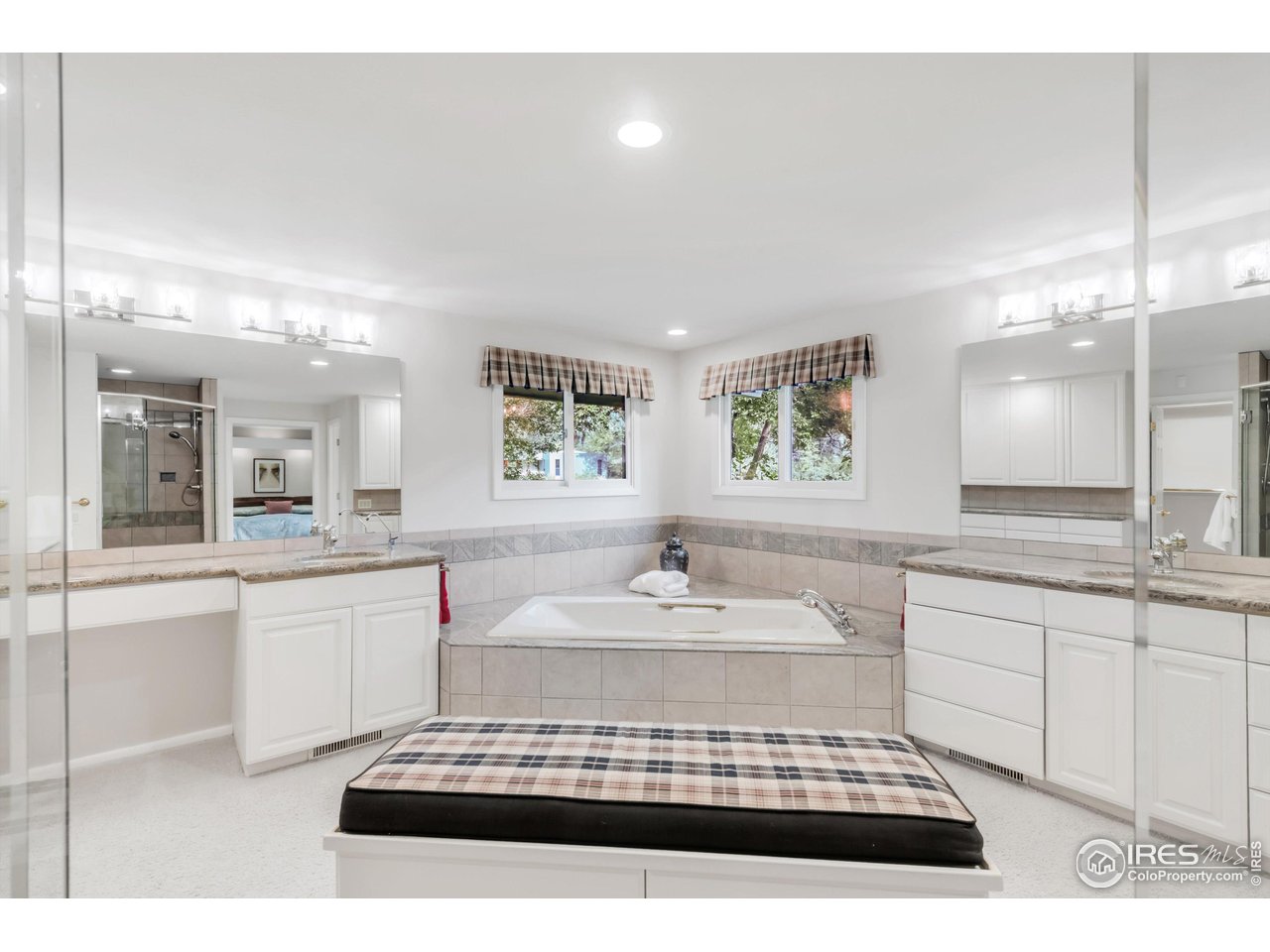 1409 Old Tale Road Boulder, CO 80303 - Photo 35 of 40 a spacious bathroom with a double vanity sink a mirror a bathtub and next to a window
