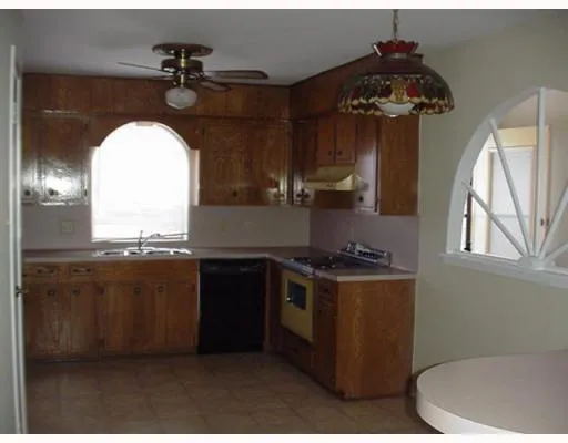 a kitchen with a stove a sink and a window