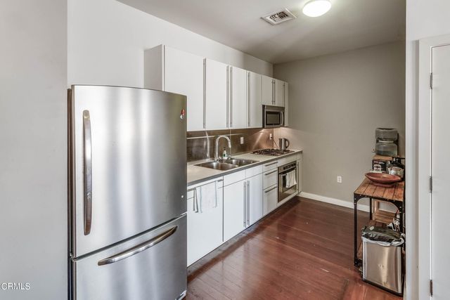 a kitchen with stainless steel appliances a refrigerator and a stove top oven