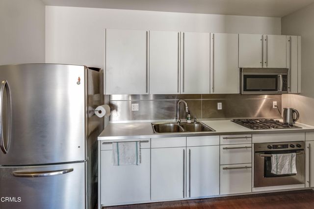 a kitchen with appliances a sink and lots of cabinets