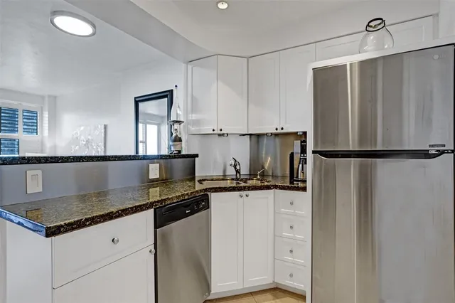 a kitchen with granite countertop a sink appliances and cabinets