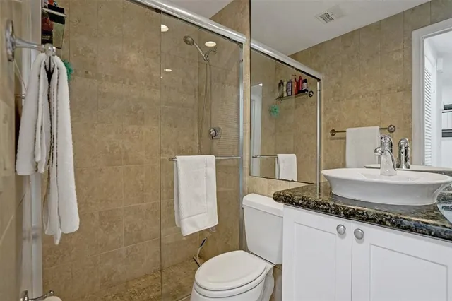 a bathroom with a granite countertop sink toilet and shower