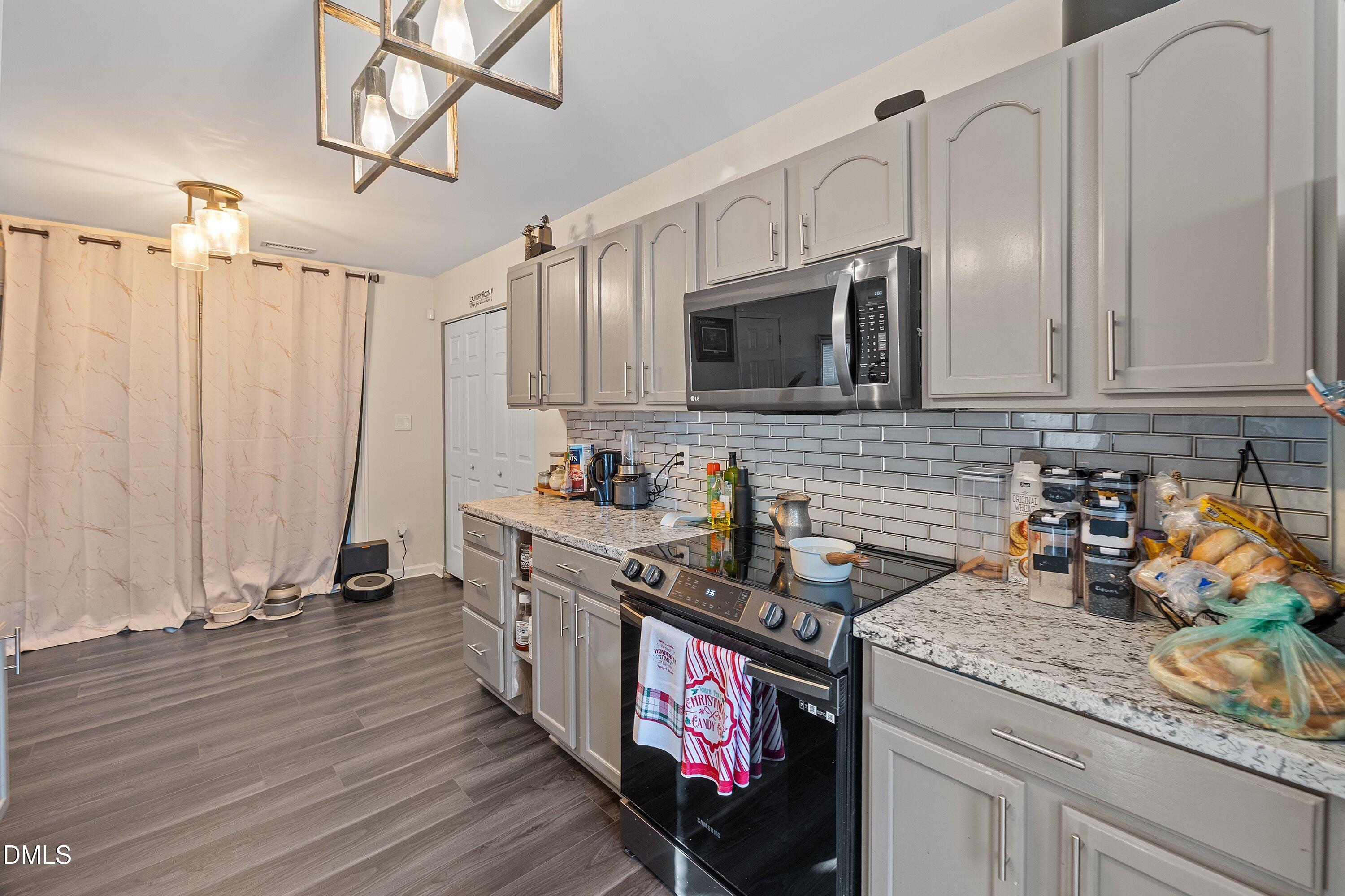2027 Buffalo Way Durham, NC 27704 - Photo 12 of 30 a kitchen with stainless steel appliances granite countertop a stove a sink dishwasher and microwave with wooden floor