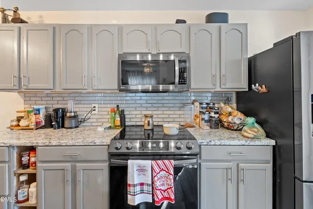 a kitchen with stainless steel appliances granite countertop a stove a sink and a refrigerator