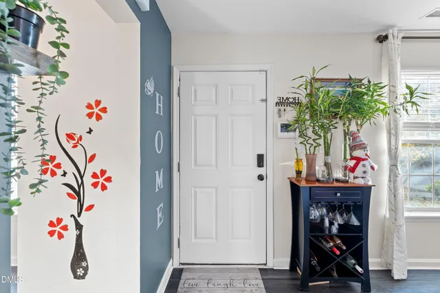 a view of a room with a mirror and hardwood floor