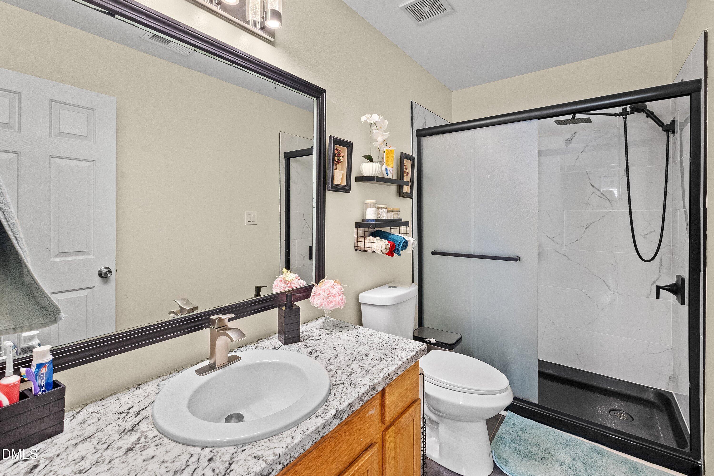 2027 Buffalo Way Durham, NC 27704 - Photo 19 of 30 a bathroom with a sink toilet and shower