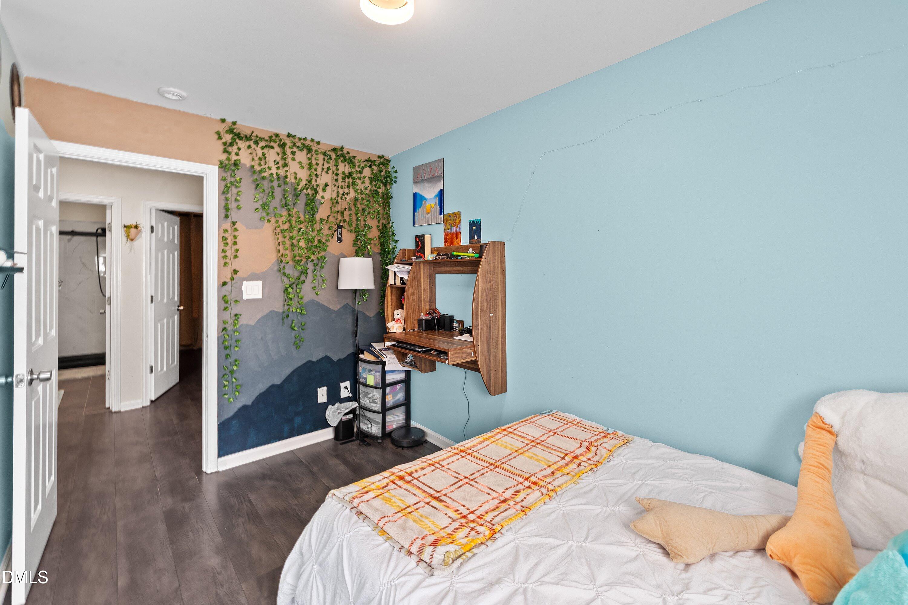2027 Buffalo Way Durham, NC 27704 - Photo 25 of 30 a bedroom with a bed and wooden floor