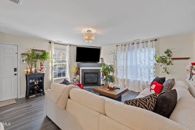 a living room with furniture a flat screen tv and a fireplace