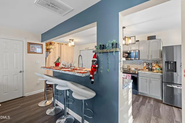 a kitchen with stainless steel appliances kitchen island granite countertop a refrigerator and a stove top oven