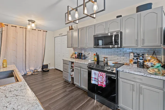 a kitchen with stainless steel appliances granite countertop a stove sink and cabinets