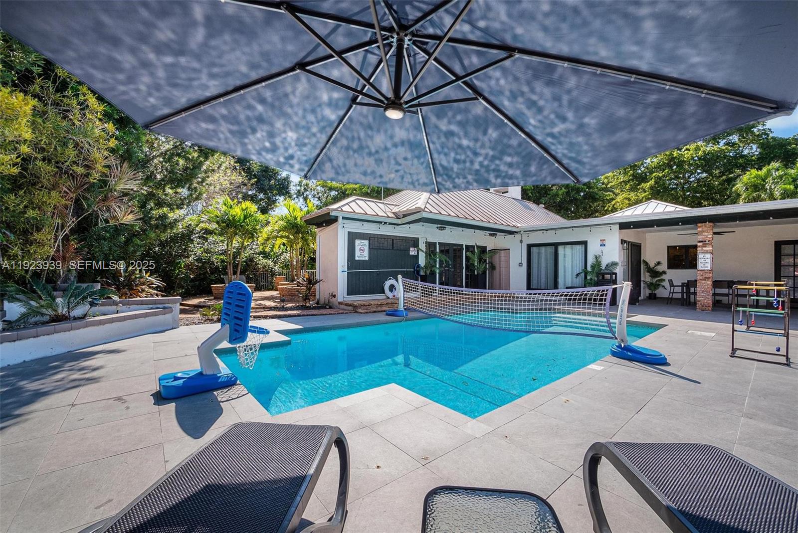 11155 Southwest 40th Street Davie, FL 33328 - Photo 26 of 74 a patio with a table and chairs under an umbrella