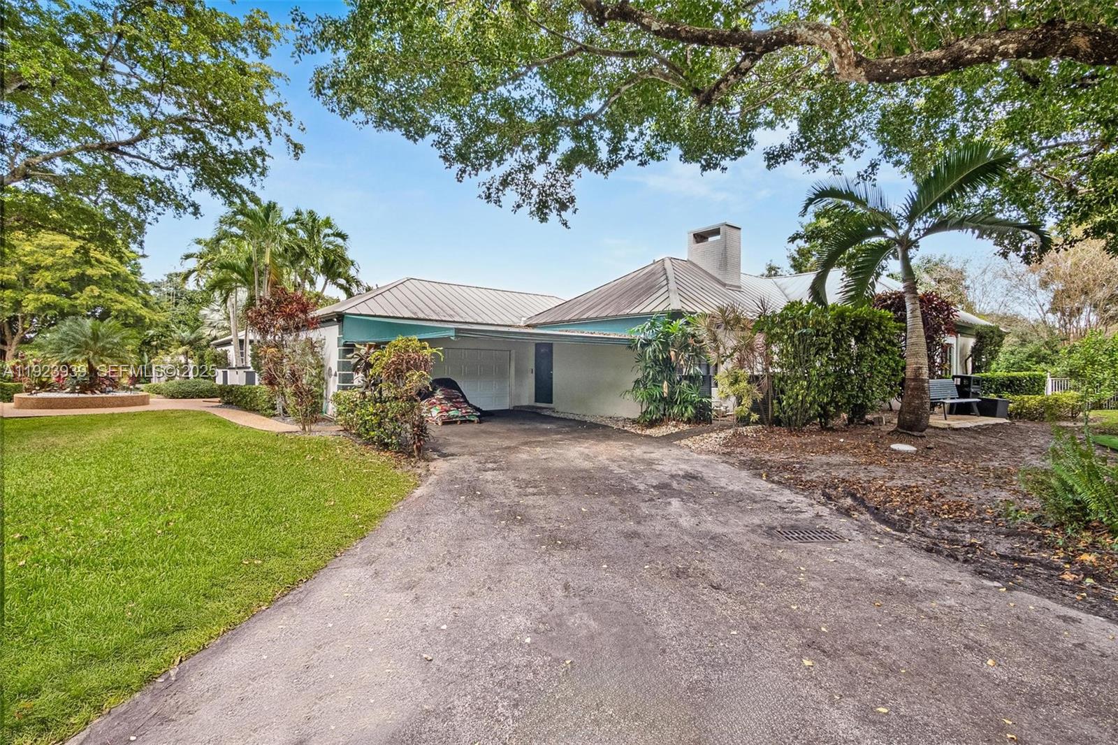 11155 Southwest 40th Street Davie, FL 33328 - Photo 30 of 74 a front view of a house with garden