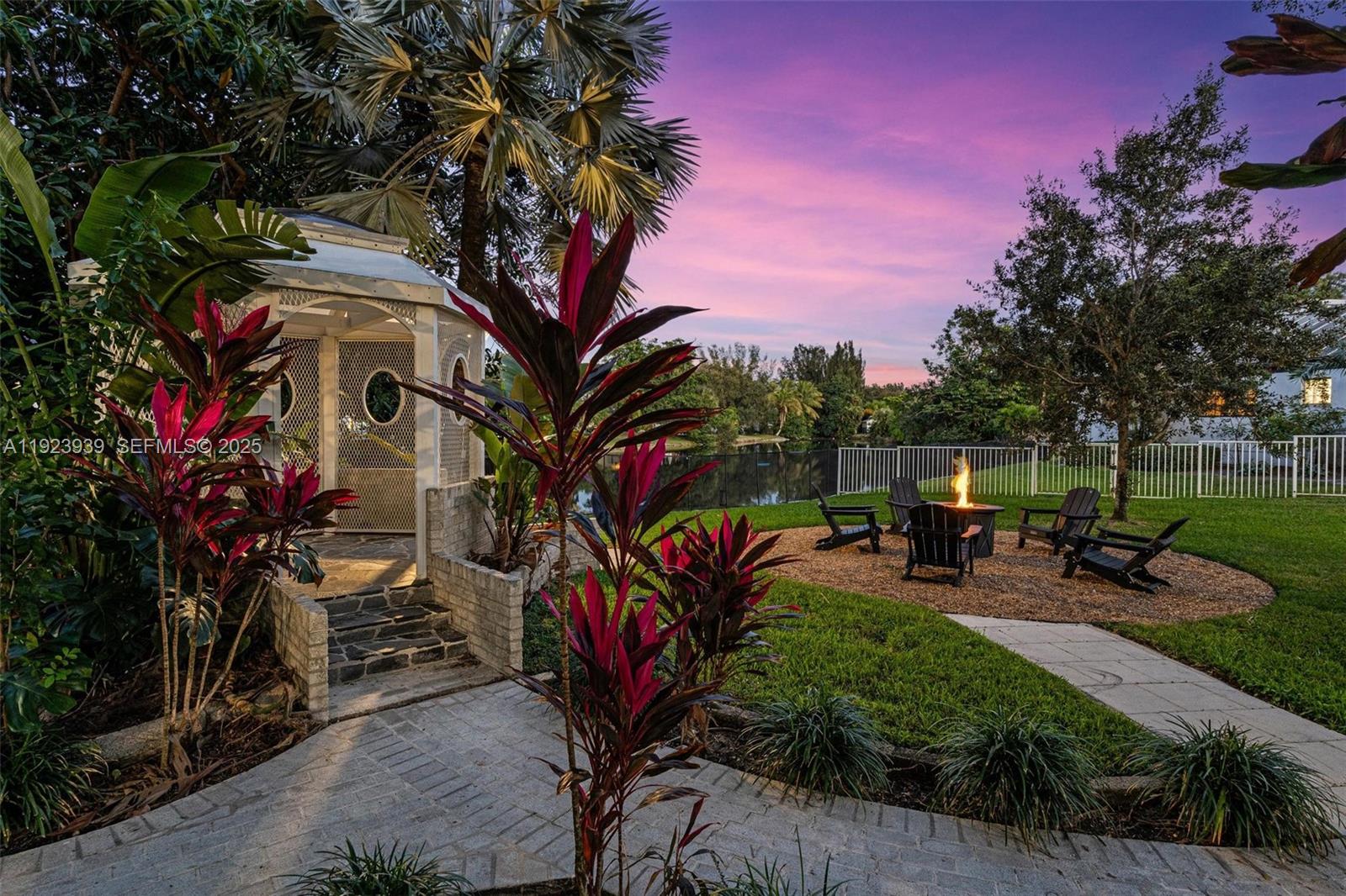 11155 Southwest 40th Street Davie, FL 33328 - Photo 43 of 74 a view of a backyard with a table and chairs and a fire pit