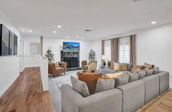 a living room with furniture fireplace and a large window