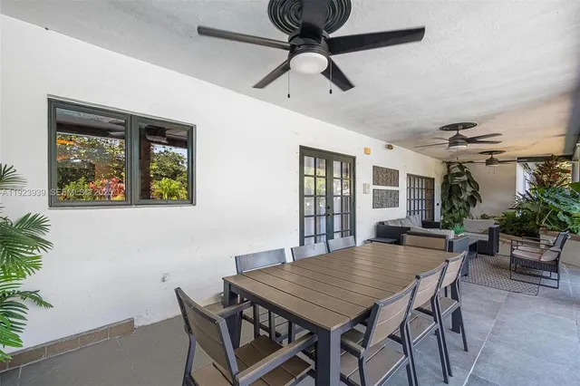 a living room with patio furniture and a potted plant