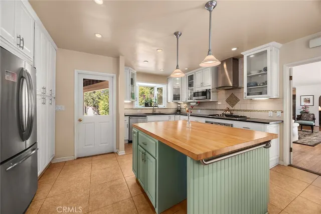 a kitchen with stainless steel appliances granite countertop counter top space a sink refrigerator and cabinets