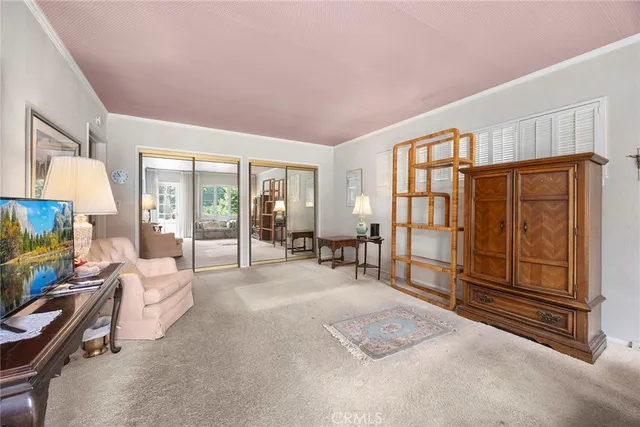 a spacious bedroom with a bed a table and flat screen tv