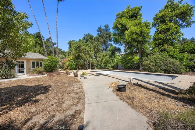 a view of house with yard and swimming pool