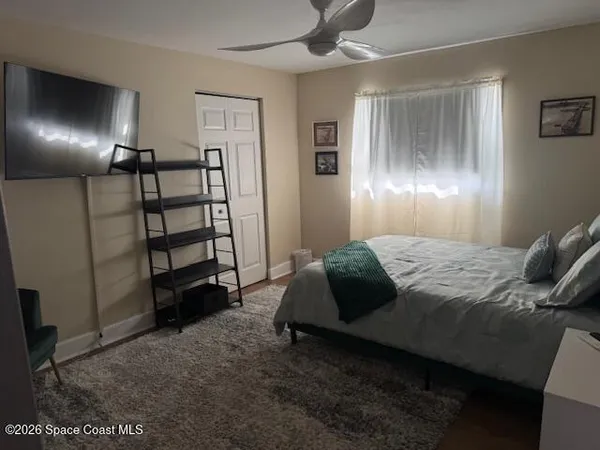 a bedroom with a bed a couch and a flat screen tv