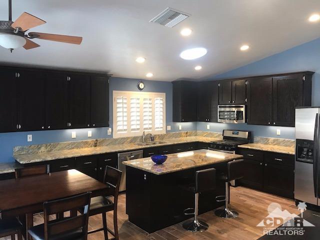 78658 Ewarton Road Bermuda Dunes, CA 92203 - Photo 2 of 10 a kitchen with a table chairs sink and cabinets