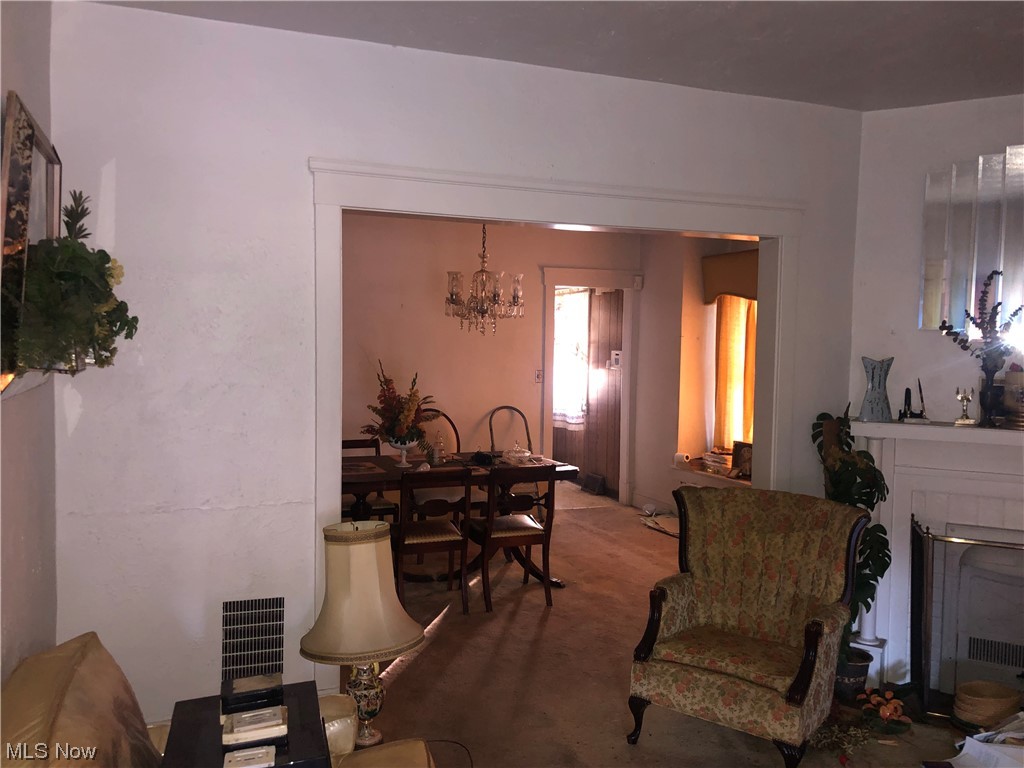 1029 Lakeview Road Cleveland, OH 44108 - Photo 6 of 22 Carpeted living room featuring a chandelier and a tiled fireplace