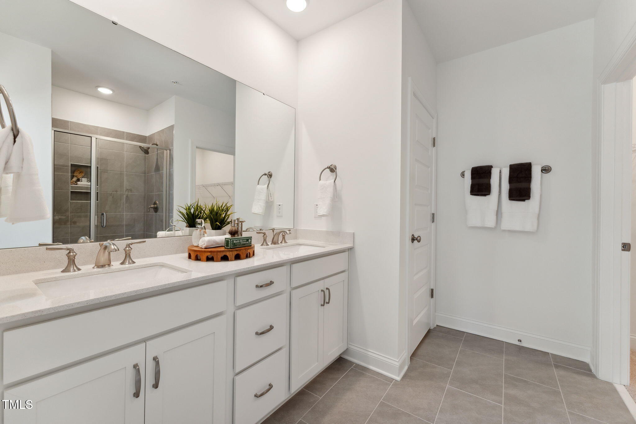 1236 South Person Street, Unit 101 Raleigh, NC 27601 - Photo 14 of 28 a bathroom with a double vanity sink and mirror