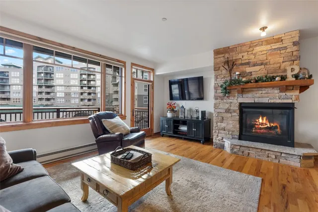 a living room with furniture a fireplace a flat screen tv and a large window