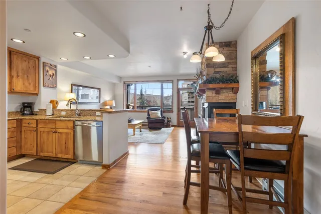 a kitchen with stainless steel appliances granite countertop a stove top oven a sink a dining table and chairs