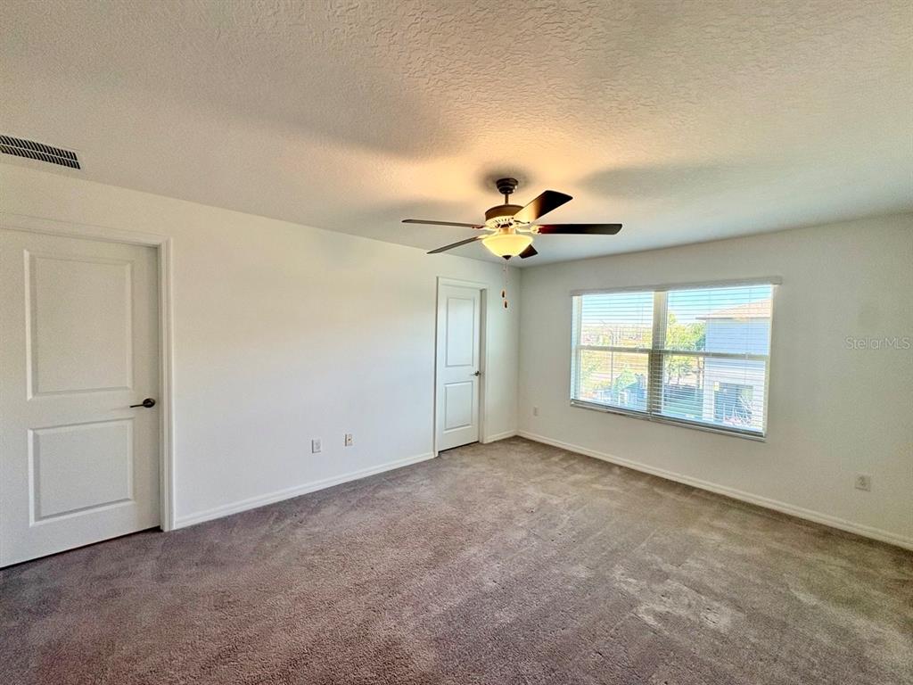 14302 Editors Note Street Ruskin, FL 33573 - Photo 12 of 28 an empty room with chandelier fan and windows