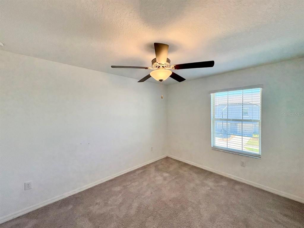 14302 Editors Note Street Ruskin, FL 33573 - Photo 14 of 28 an empty room with a window and a ceiling fan