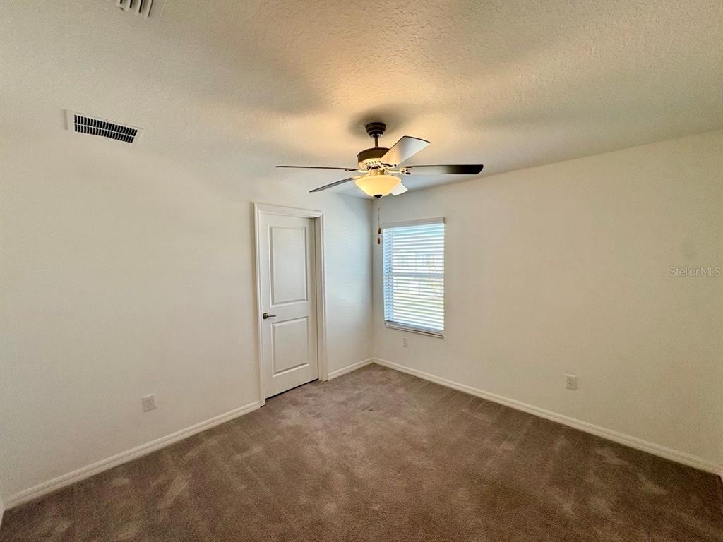 14302 Editors Note Street Ruskin, FL 33573 - Photo 21 of 28 a view of an empty room with a chandelier fan
