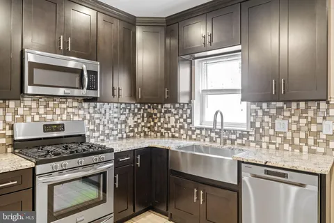 a kitchen with stainless steel appliances wooden cabinets and a stove top oven