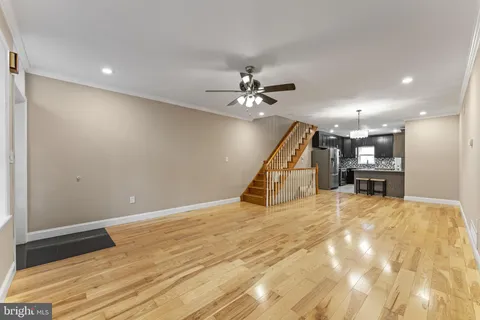 a view of a livingroom with a ceiling fan and wooden floor